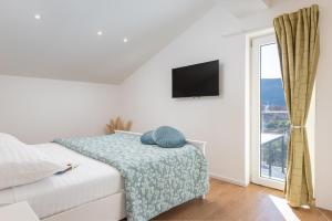 a white bedroom with a bed and a window at Villa Magnolia with heated Pool and Jacuzzi, near sea in Tugare +47 photos