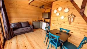 a living room with a table and chairs and a couch at oda lux nikortsminda in Ambrolauri