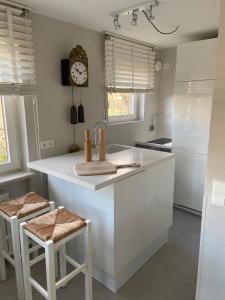 a kitchen with a sink and a clock on the wall at Apartes Studio am See in Hagnau
