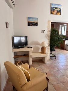 a living room with a television and a chair at Maison de village en Provence in Mouriès