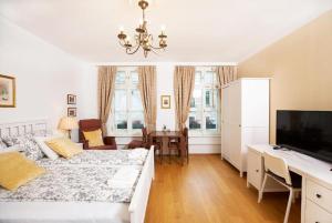 sala de estar con cama y escritorio con TV en Augarten Apartments, en Viena