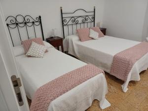 a bedroom with two beds with pink and white sheets at Casa La Culle in Favareta +44 photos