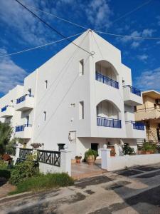 a white building with blue balconies on it at Ilios Suites in Kato Gouves