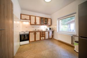 una piccola cucina con mobili in legno e una finestra di Dom v lokalite so slovenským orlojom a Stará Bystrica