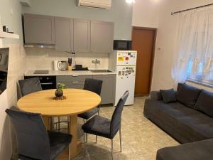 a kitchen and living room with a table and a couch at Apartman Mila - free parking and WiFi in Rijeka +12 photos
