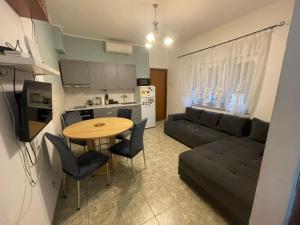 a kitchen and living room with a table and a couch at Apartman Mila - free parking and WiFi in Rijeka