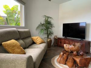 a living room with a couch and a flat screen tv at Krisant Gold Rural Luxury Privat Pool in Santa Cruz de Tenerife