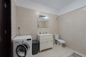 a bathroom with a washing machine and a washer at Luxury Apartment in Râmnicu Vâlcea +38 photos