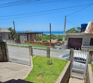 una recinzione bianca con l'oceano sullo sfondo di House views of Imbituba Beach a Imbituba