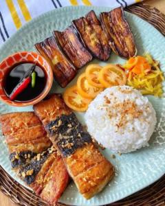 a plate of food with rice and different types of food at Laly's B8 cozy Vacation Townhouse in Olongapo