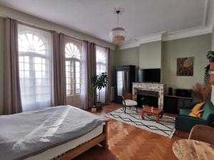 a bedroom with a bed and a living room with a fireplace at Maison d'hôtes de Xavier in Brussels