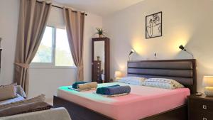 a bedroom with a pink bed with two towels on it at CSS Comfy Smart Superior By King's Palace in Paphos City