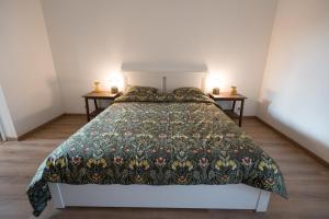 Un dormitorio con una cama con una colcha floral. en Cozy apartement in the heart of Brussels, en Bruselas