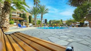 a wooden bench sitting next to a swimming pool at CSS Comfy Smart Superior By King's Palace in Paphos City