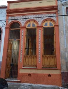 un bâtiment orange avec de grandes fenêtres sur une rue dans l'établissement Casarão Campina, à Belém