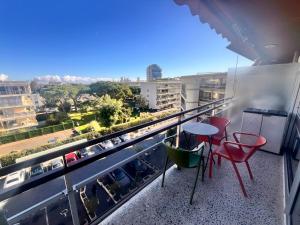 Heliotel Marine Studio avec balcon au 4eme étage à 200m de la mer في سان لوران دو فار: شرفة مع طاولة وكراسي وإطلالة على المدينة