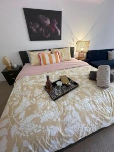 a bedroom with a large bed with a tray on it at City at Your Doorstep in Sydney