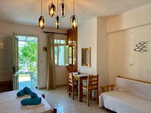 a bedroom with a bed and a dining room with a table at Pansion Episkopi Studios in Skopelos Town
