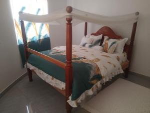 a bedroom with a bed with a canopy at Otogo Guest House in Gulu
