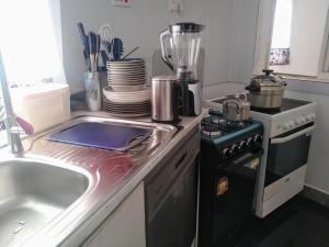 a kitchen with a sink and a stove and a counter top at Otogo Guest House in Gulu