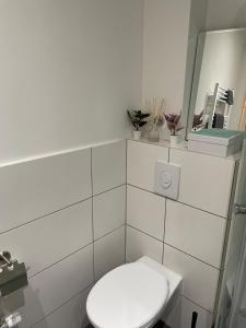 ein weißes Badezimmer mit Toilette und Spiegel in der Unterkunft Apartment im Herzen von Lübeck in Lübeck