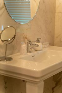 a bathroom sink with a mirror on top of it at Locanda Gaudemus Boutique Hotel in Sistiana