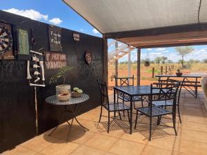 a dining room with a table and chairs and a dartboard at Gecko Accommodation in Hotazel
