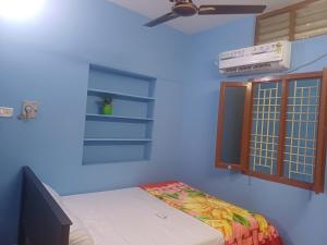 蒂鲁瓦纳马莱Lakshmi Homes Homestay-2的客房设有床、电视和窗户。