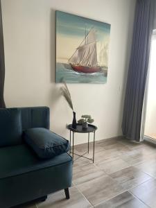 a living room with a green couch and a painting of a sail boat at Accommodation Ventus 2 in Baška Voda