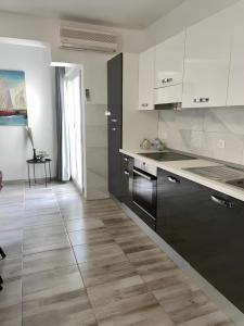 a kitchen with white and black cabinets and a wooden floor at Accommodation Ventus 2 in Baška Voda +19 photos