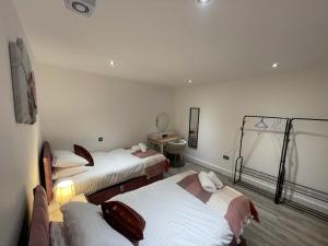 a hotel room with three beds and a table at Kings Lodge By Nivaas 2 in Reading