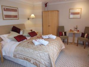 a hotel room with a bed with towels on it at Ashburnham Hotel in Pembrey