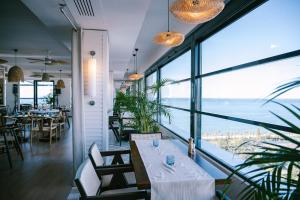 a restaurant with a table and a view of the ocean at White apartment in Minda