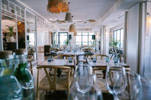 a restaurant with a long table with chairs and wine glasses at White apartment in Minda