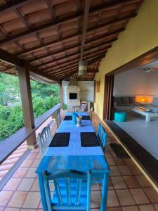 une table et des chaises bleues sur une terrasse dans l'établissement Casa Exclusiva na Falésia - Barraca da Maré, Arraial d'Ajuda, à Arraial d'Ajuda
