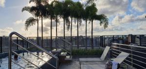 ein Pool mit Palmen auf einem Gebäude in der Unterkunft Flat Por Temporada no Edifício Time Maceió-AL in Maceió