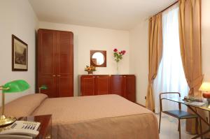 a bedroom with a bed and a desk with a phone at Hotel Residence Vatican Suites in Rome