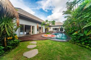a backyard with a swimming pool and a house at Luxury-Sang Villa- Central Sanur in Sanur