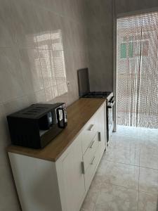 un microondas en la parte superior de un mostrador en la cocina en Apartament Luxor, en Linares