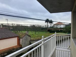 a balcony of a house with a white fence at Grupo Gontad Casa Secundino in Asalo