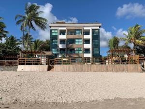 a building on the beach with palm trees at Plage du Porto in Porto De Galinhas