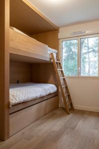a small bedroom with a bunk bed and a window at Hossegor-T3-Lake-Family in Hossegor
