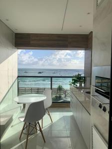 Una cocina con mesa y vista al mar. en Plage du Porto, en Porto de Galinhas