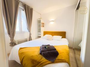 a bedroom with a bed with a yellow blanket and a window at L'échappée verte - T2 - Confort -Piscine - Tennis- Parking - Climatisation - SudSéjourConciergerie in Canet-en-Roussillon +21 photos