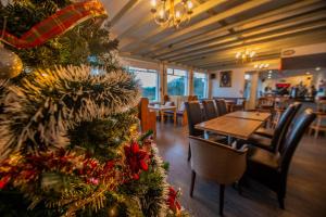 a christmas tree in a restaurant with tables and chairs at Greenfield Lodge Hotel Bar & Bistro in Headford