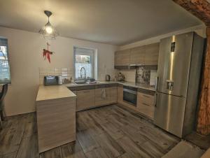 a kitchen with wooden floors and a stainless steel refrigerator at Streamside apartment in Jarkowice