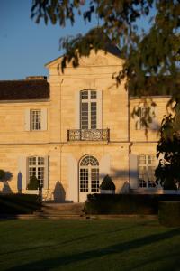 a large white building with a balcony on it at Château du Tertre in Arsac