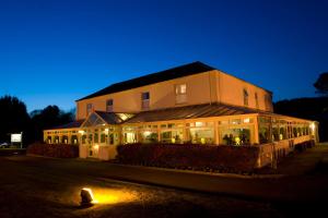 a building with lights in front of it at night at Ashburnham Hotel in Pembrey