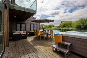 eine Terrasse mit einem Pool, einem Tisch und einer Badewanne in der Unterkunft Ardross Lodge in South Cerney