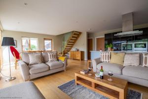 ein Wohnzimmer mit zwei Sofas und einem Tisch in der Unterkunft Ardross Lodge in South Cerney